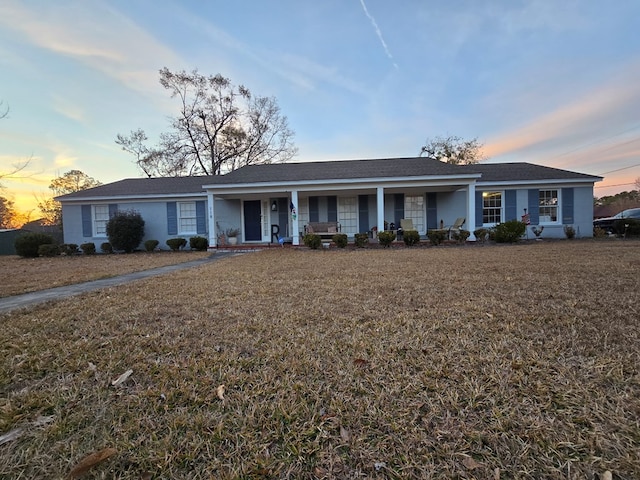 single story home with a porch and a front lawn