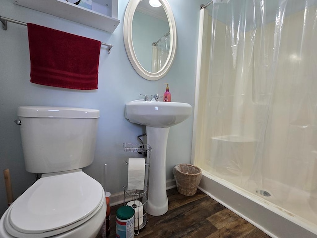 full bath with baseboards, wood finished floors, toilet, and a shower stall