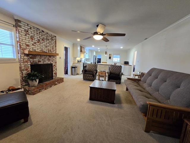 living area with recessed lighting, ornamental molding, a brick fireplace, light carpet, and ceiling fan