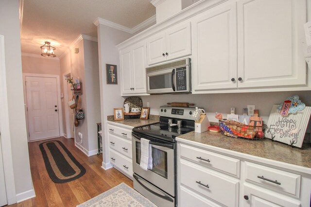 5300 Hidden Oaks Blvd, Lake Park, GA 31636 - kitchen with stainless steel appliances, crown molding, wood finished floors, white cabinets, and a chandelier