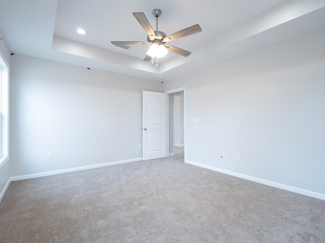 carpeted spare room featuring a raised ceiling, baseboards, a ceiling fan, and recessed lighting
