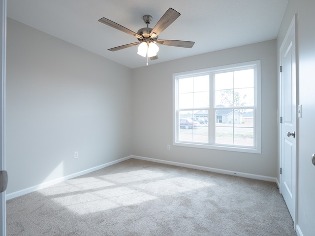 empty room featuring carpet, baseboards, and a ceiling fan