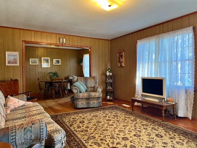 living room featuring hardwood / wood-style flooring and wood walls