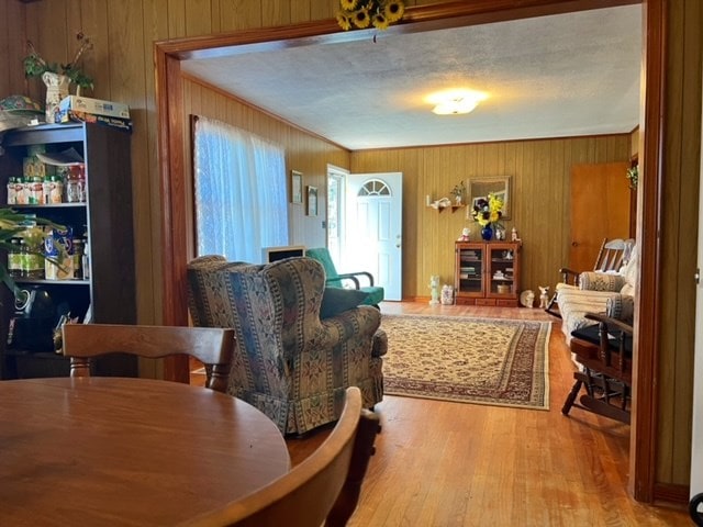 dining area with light hardwood / wood-style flooring and wooden walls