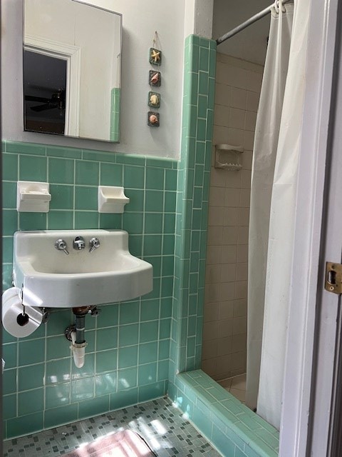 bathroom featuring a shower with shower curtain, tile patterned floors, tile walls, and sink