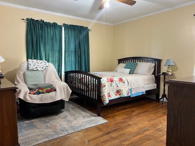 bedroom with ceiling fan, hardwood / wood-style floors, and ornamental molding