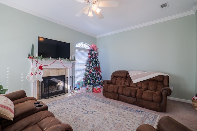 living room featuring ceiling fan, a fireplace, and ornamental molding