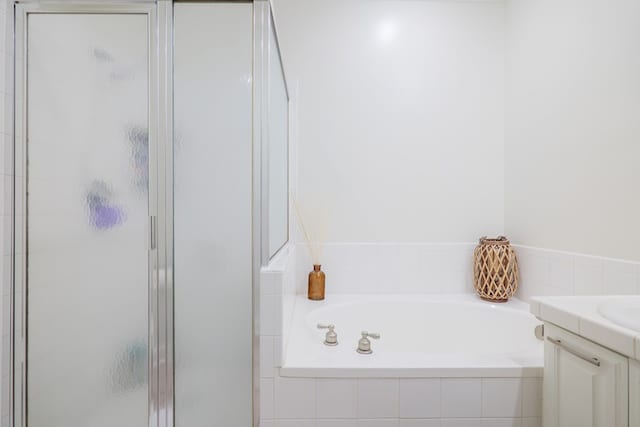 bathroom featuring vanity and separate shower and tub