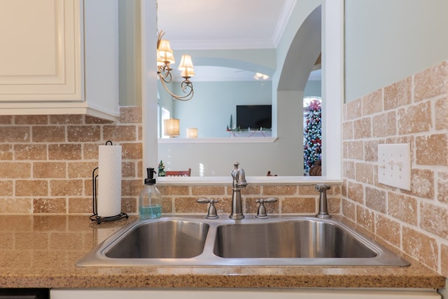 kitchen featuring decorative backsplash, sink, and ornamental molding