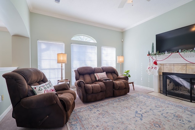 living room featuring ceiling fan, a fireplace, light carpet, and ornamental molding