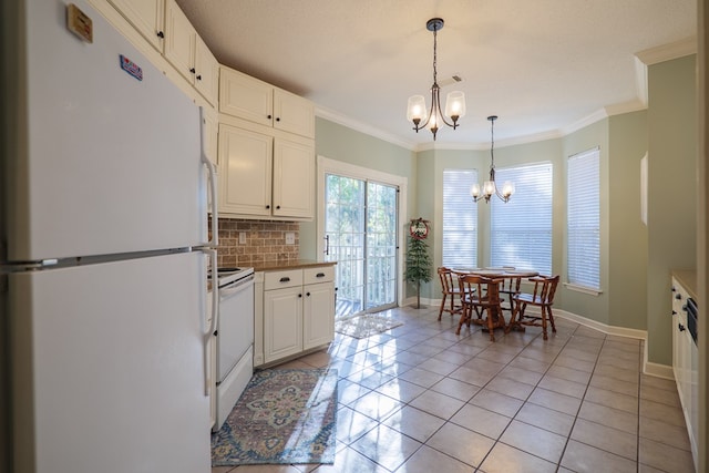 kitchen with tasteful backsplash, a notable chandelier, white cabinets, range, and white fridge