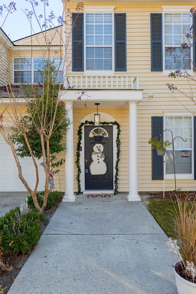 doorway to property with a balcony and a garage