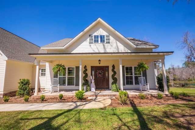 view of front of house featuring covered porch and a front lawn