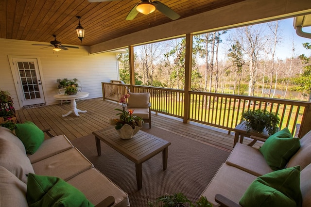 wooden deck with outdoor lounge area and ceiling fan