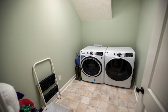 clothes washing area featuring washer and clothes dryer, heating unit, a textured ceiling, baseboards, and laundry area