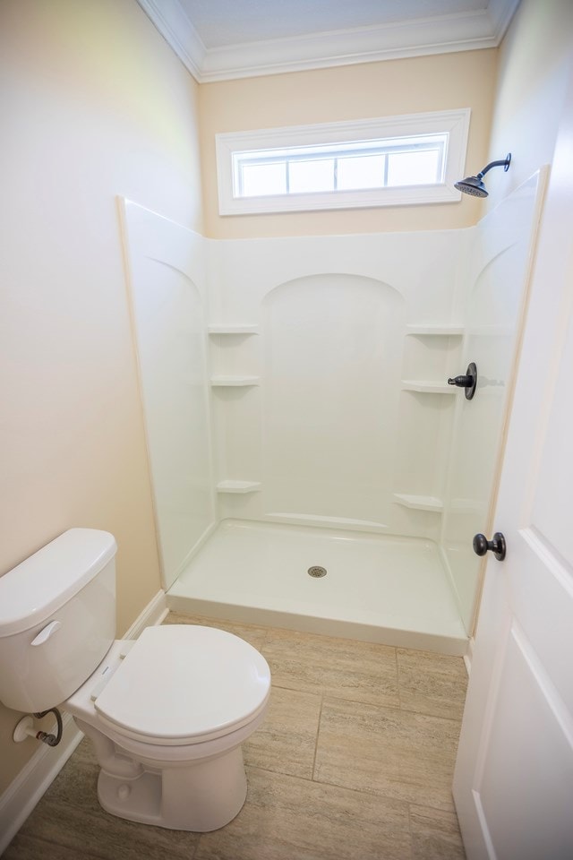 full bath with wood finished floors, toilet, a walk in shower, and ornamental molding