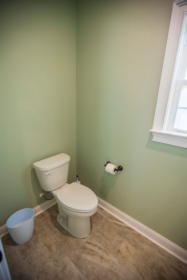 bathroom with tile patterned flooring, toilet, and baseboards