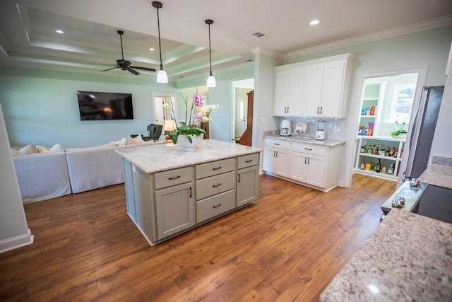 kitchen with a tray ceiling, tasteful backsplash, open floor plan, dark wood-style floors, and white cabinets