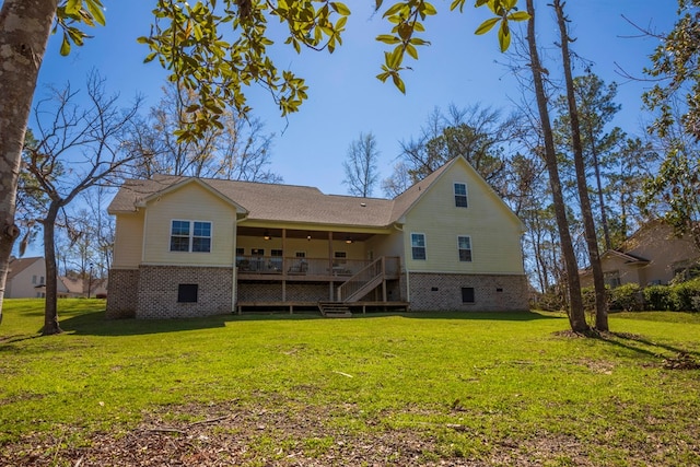 back of property with a wooden deck, a lawn, and brick siding