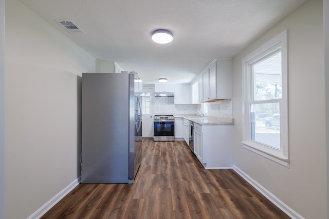 kitchen featuring white cabinetry, sink, stainless steel appliances, dark hardwood / wood-style floors, and decorative backsplash