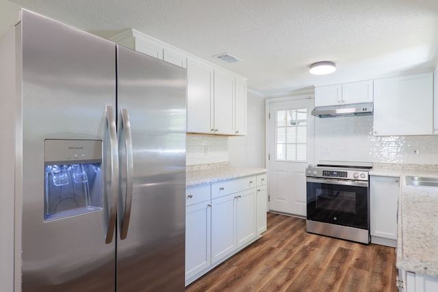 kitchen with decorative backsplash, white cabinetry, dark wood-type flooring, and appliances with stainless steel finishes