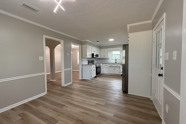 4604 Pinebrook Dr, Lake Park, GA 31636 - kitchen with stainless steel appliances, arched walkways, a textured ceiling, crown molding, and wood finished floors