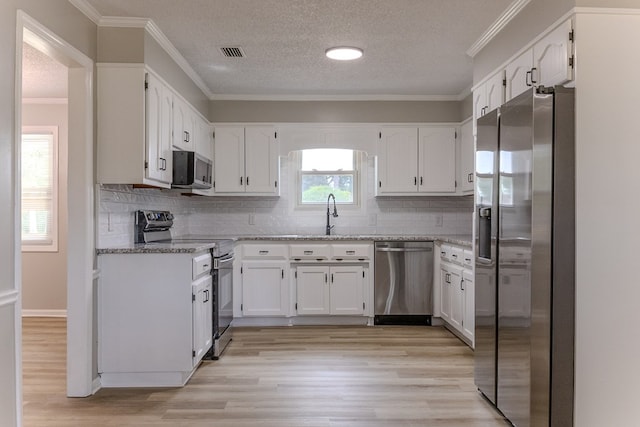 4604 Pinebrook Dr, Lake Park, GA 31636 - kitchen featuring appliances with stainless steel finishes, white cabinets, a textured ceiling, and ornamental molding