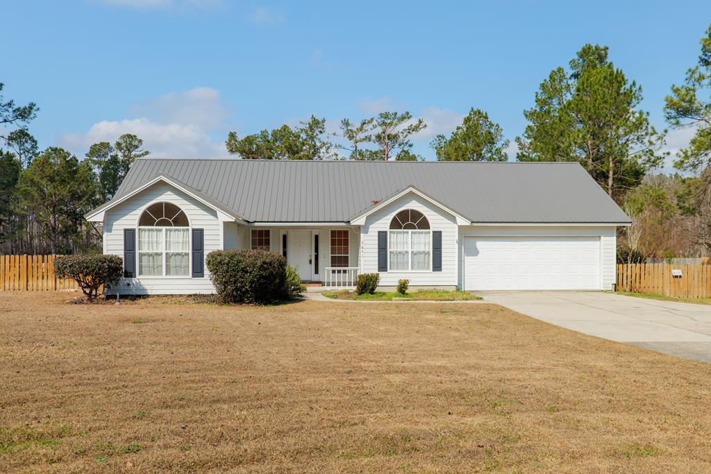 ranch-style house featuring a garage and a front lawn