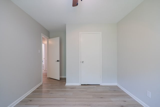 unfurnished bedroom featuring ceiling fan, light hardwood / wood-style floors, and a closet