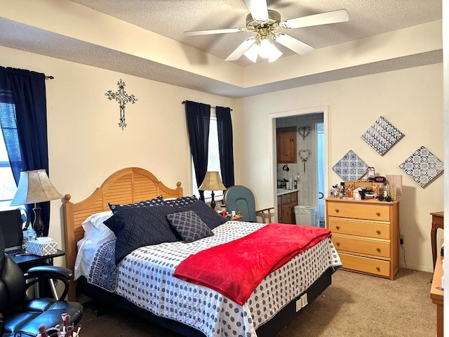 bedroom with a tray ceiling, a ceiling fan, a textured ceiling, and light colored carpet