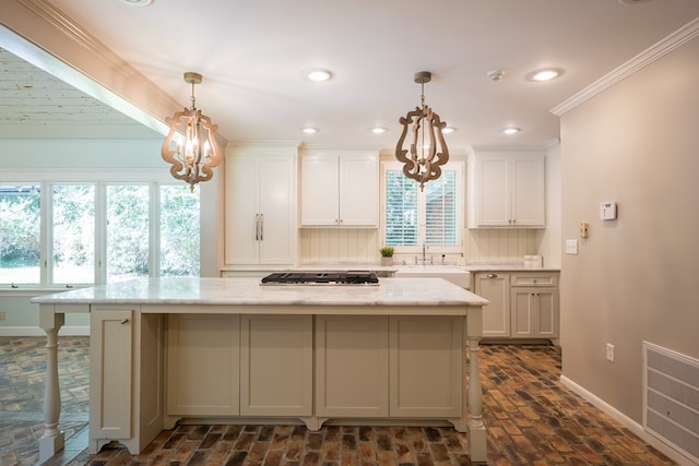 kitchen with tasteful backsplash, light stone counters, stainless steel gas cooktop, decorative light fixtures, and white cabinets