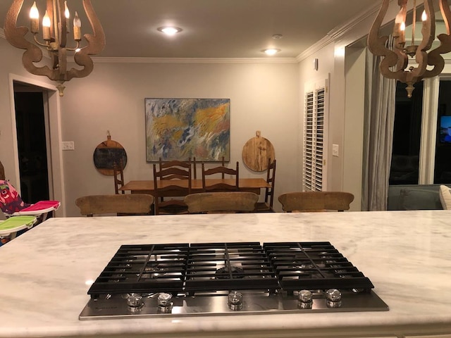 kitchen with black gas cooktop, crown molding, and a notable chandelier