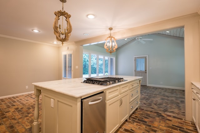 kitchen featuring decorative light fixtures, a kitchen island, stainless steel gas cooktop, and crown molding