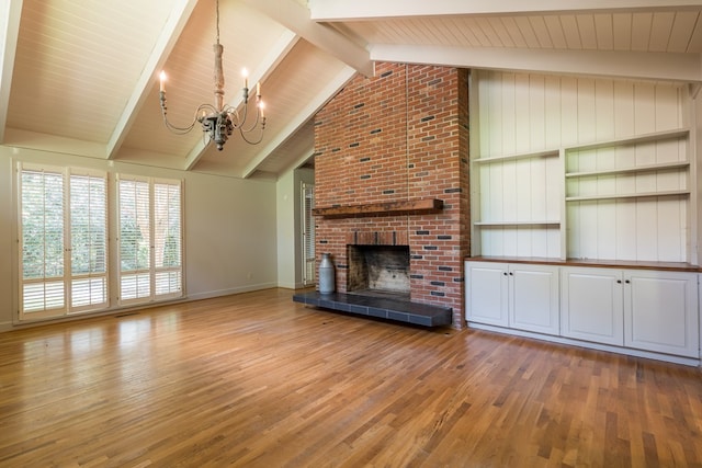 unfurnished living room with a brick fireplace, lofted ceiling with beams, a notable chandelier, and light wood-type flooring