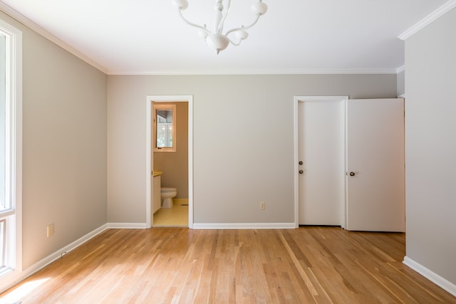 unfurnished bedroom featuring connected bathroom, light hardwood / wood-style flooring, a notable chandelier, a closet, and ornamental molding