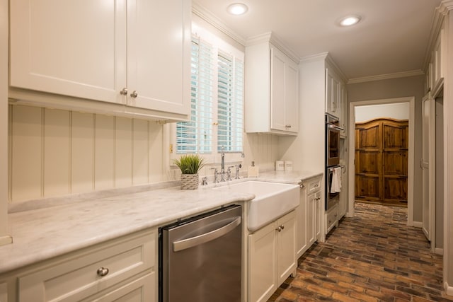 kitchen featuring sink, ornamental molding, light stone counters, white cabinetry, and stainless steel appliances