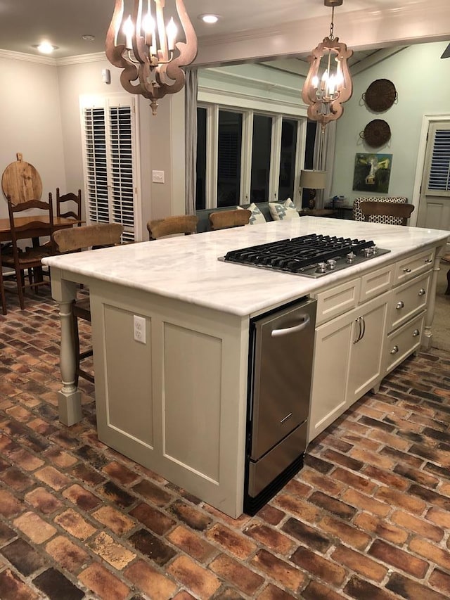 kitchen with pendant lighting, a center island, a kitchen breakfast bar, ornamental molding, and a chandelier