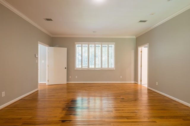 empty room featuring light wood-type flooring and ornamental molding