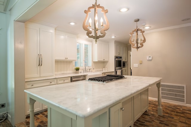 kitchen with pendant lighting, a kitchen island, light stone countertops, and stainless steel appliances