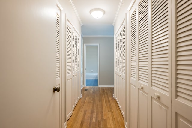 hall featuring light wood-type flooring and ornamental molding