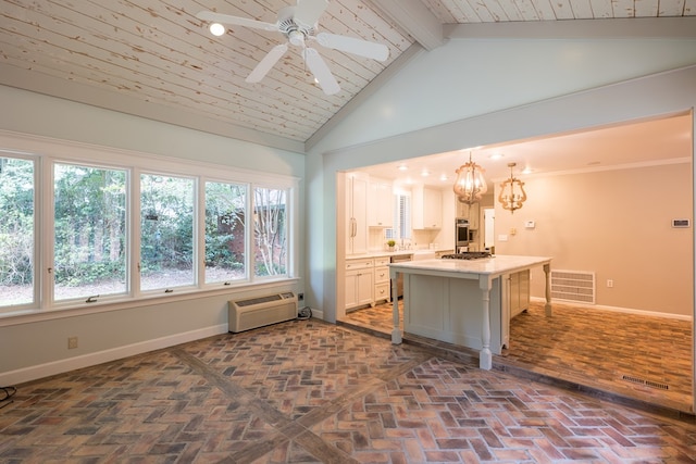 interior space featuring a center island, appliances with stainless steel finishes, decorative light fixtures, a kitchen bar, and white cabinetry