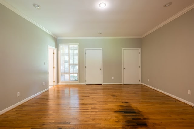 unfurnished room featuring hardwood / wood-style flooring and crown molding