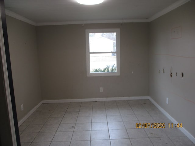 tiled empty room featuring crown molding