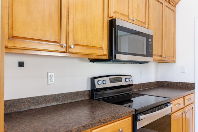 kitchen with appliances with stainless steel finishes and dark countertops