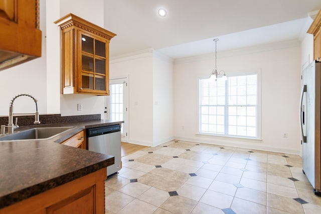 kitchen featuring dark countertops, brown cabinetry, freestanding refrigerator, a sink, and dishwasher