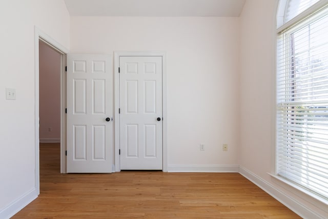 unfurnished bedroom featuring light wood-style floors and baseboards