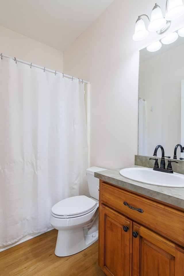 full bathroom featuring toilet, wood finished floors, and vanity