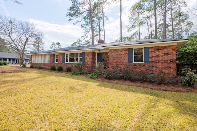 single story home with a front yard, brick siding, and a chimney