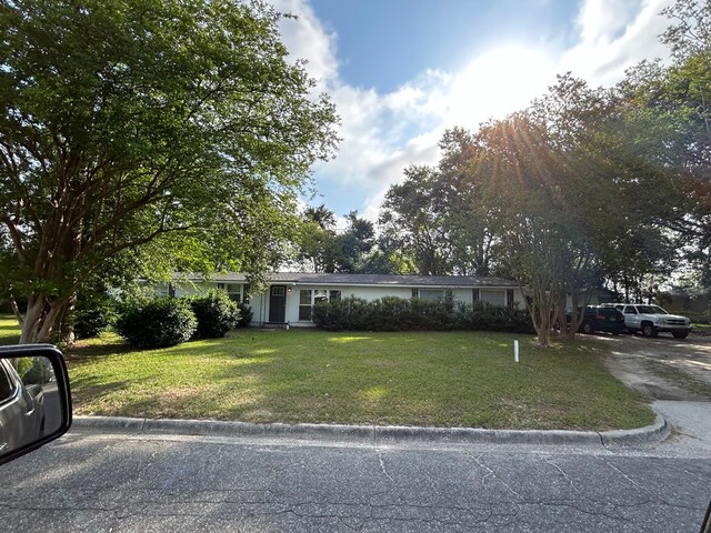 ranch-style home featuring a front lawn