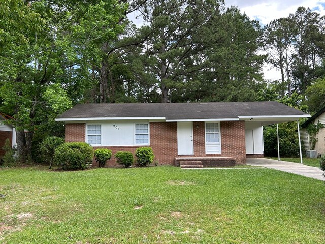 ranch-style home with central AC, a front lawn, and a carport